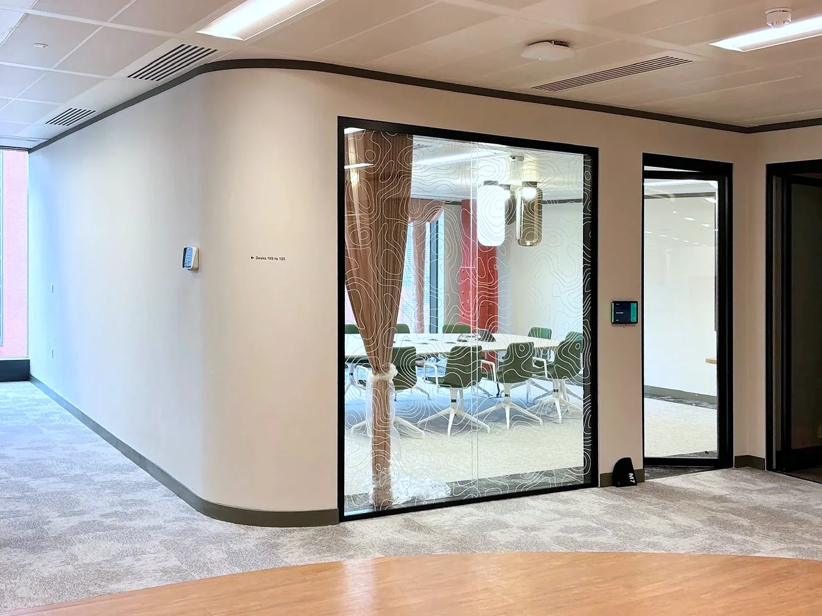 The junction between a curved partition, glazed room front and ceiling