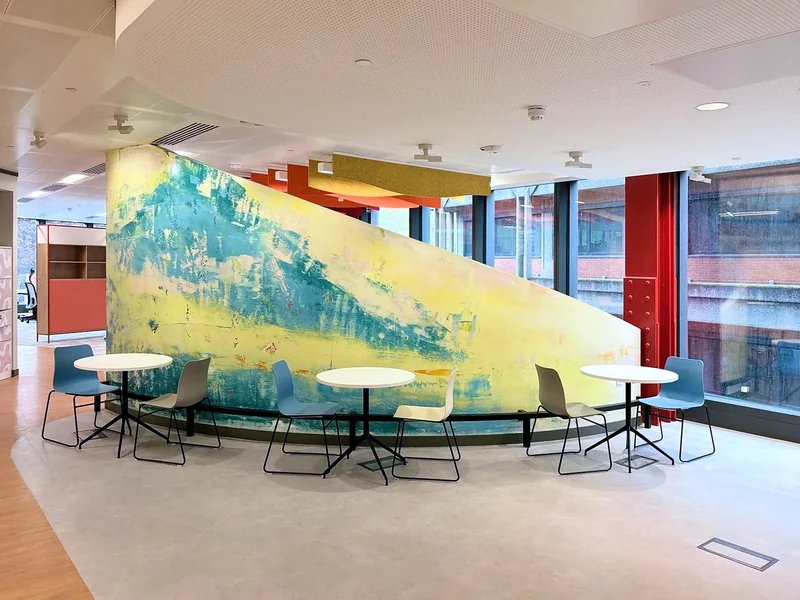 A curved feature wall separates the shared meeting space