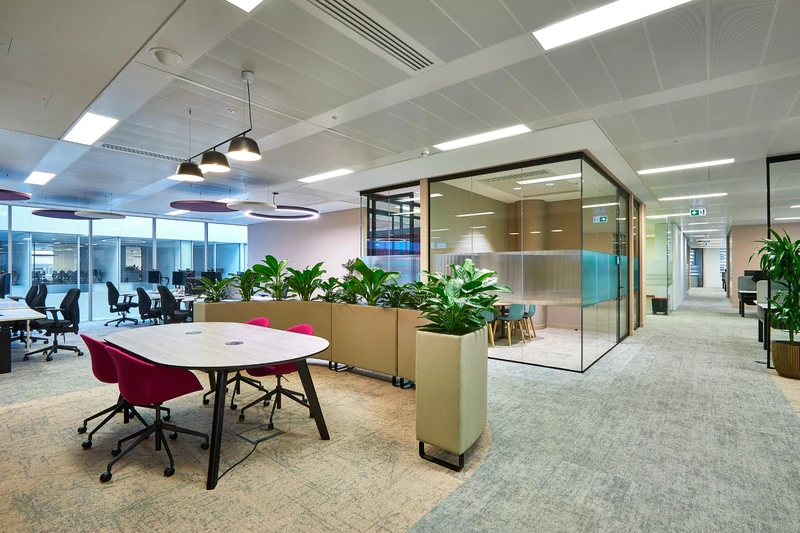 A glazed meeting room beside the open-plan workspace