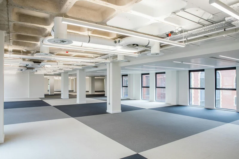 Exposed service zones meet the lower perimeter ceiling