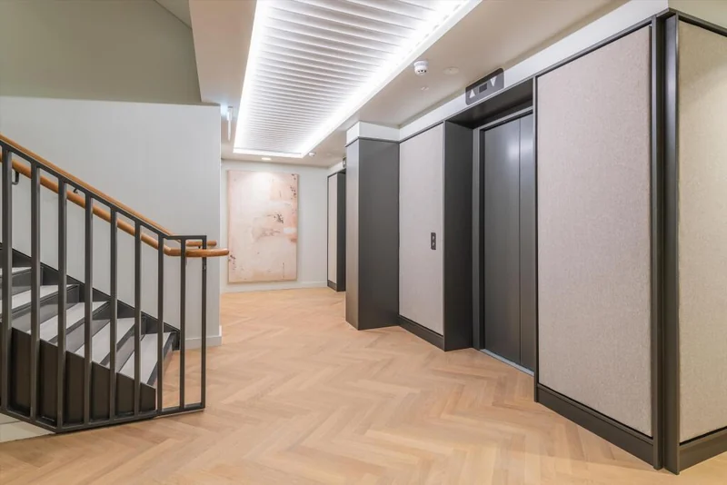 A recessed ceiling feature alongside the wall panels and access doors