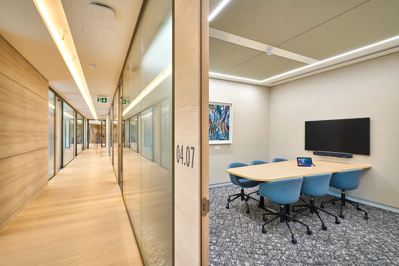 Timber-lined corridor with clean junctions at the meeting-room fronts