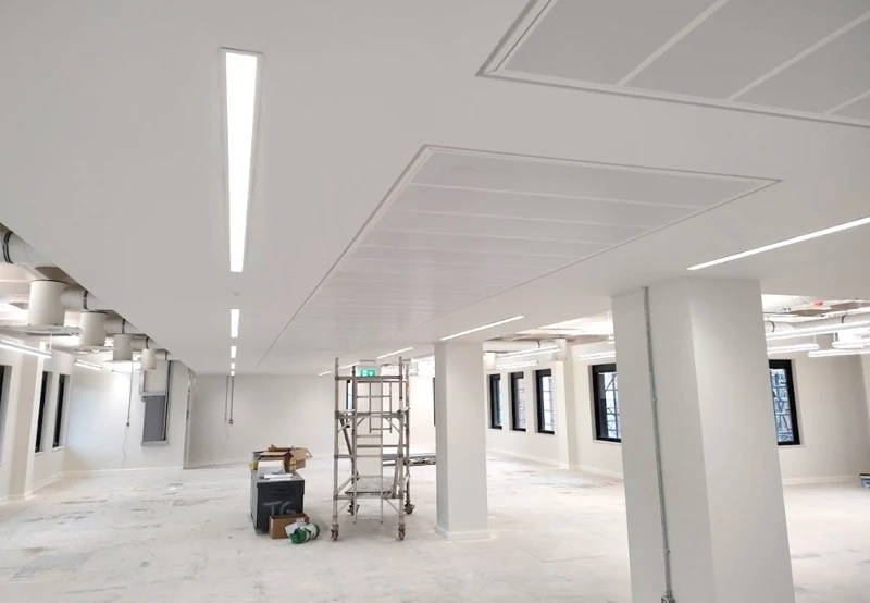 Ceiling installation and finishing works across an open-plan office floor.